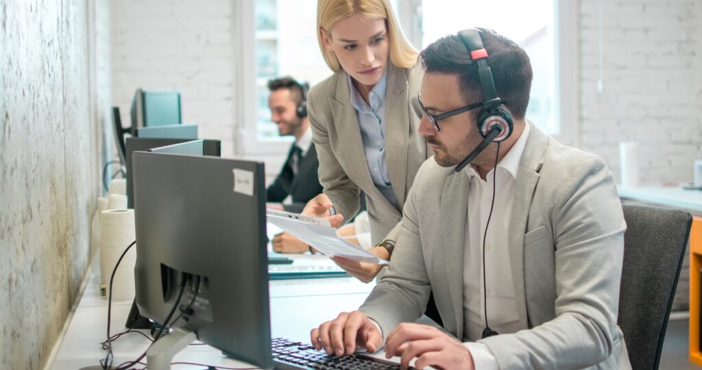 Business woman showing document to her male colleague at the office